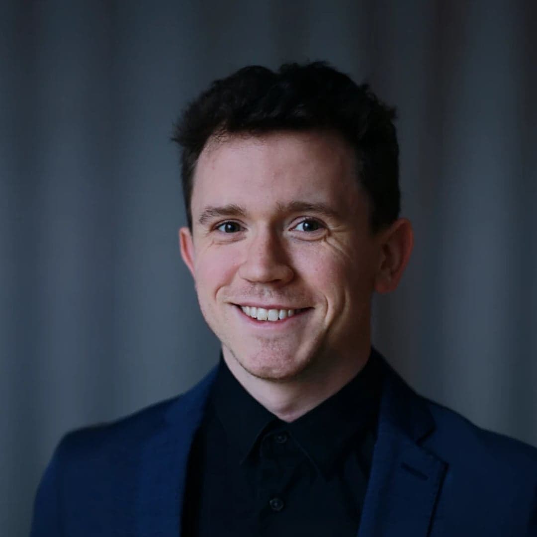 Stefan Sand brosandi í bláum jakka.
