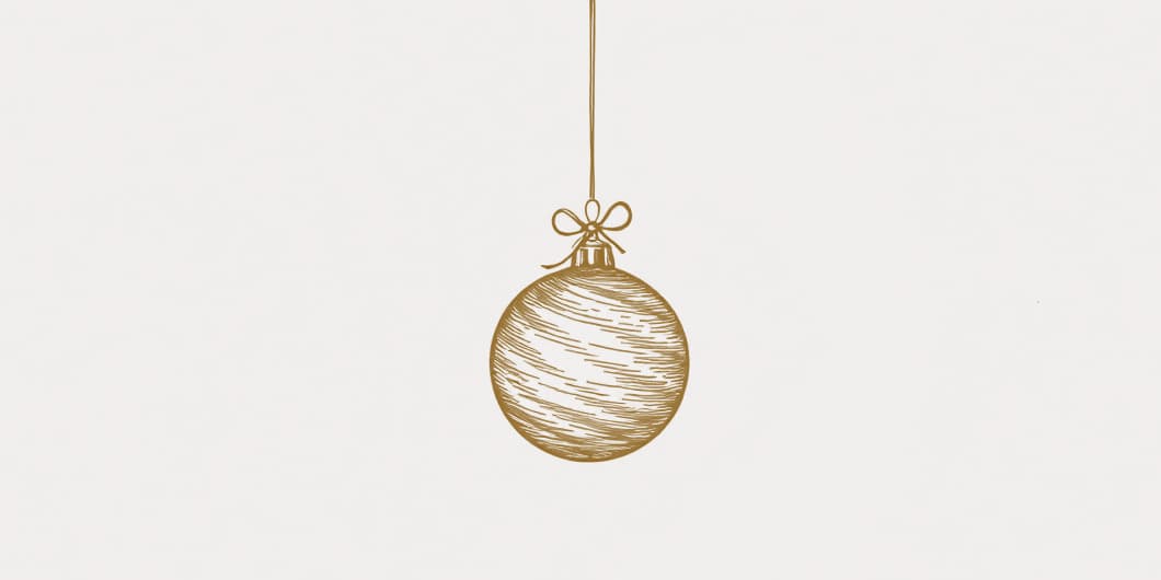 A drawing of a Christmas bauble hanging by a thread below a small bow, in gold line on pale paper.