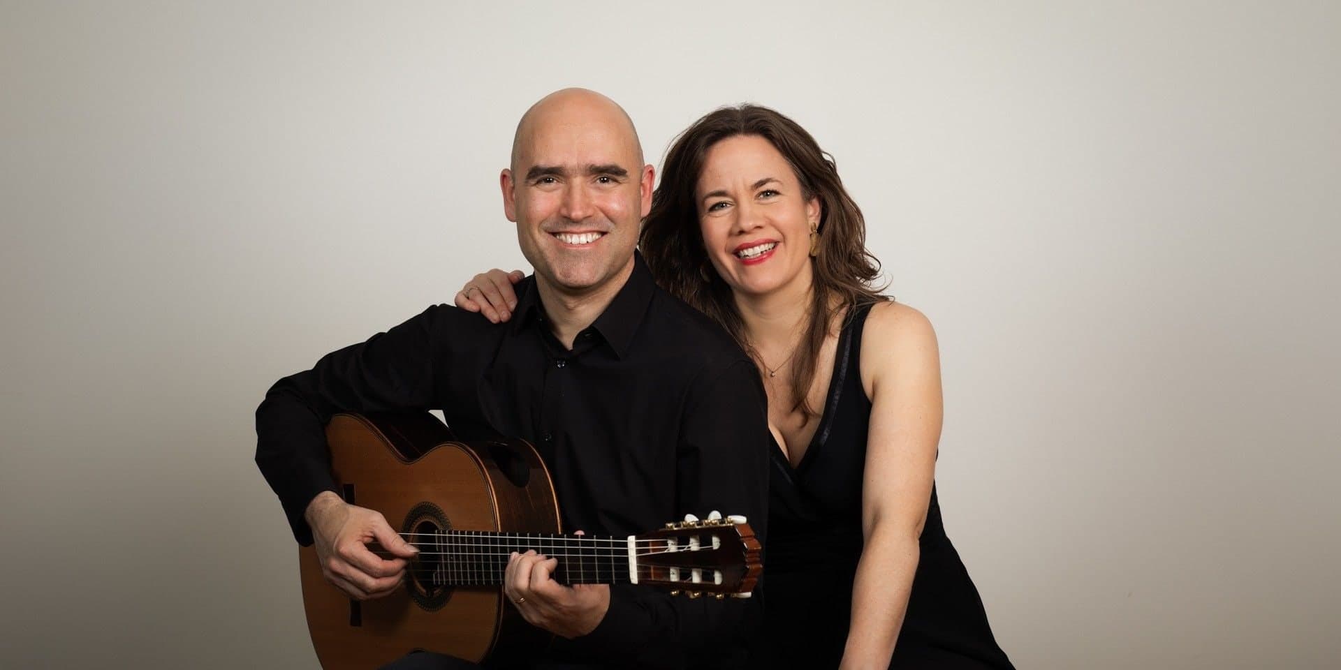 Francisco Javier Jáuregui seated with his guitar, and Guðrún Jóhanna Ólafsdóttir leaning on his shoulder.